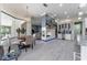 Open-concept living and dining area with modern fireplace, neutral tones, and elegant light fixtures at 1111 Myrtle Breezes Ct, Fruitland Park, FL 34731