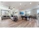 Spacious living room boasts wood floors, comfortable sofas, and a stylish billiard table near the windows at 1111 Myrtle Breezes Ct, Fruitland Park, FL 34731