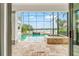 The screened-in pool area includes a water feature and integrated spa with views of the lake at 1111 Myrtle Breezes Ct, Fruitland Park, FL 34731
