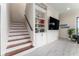 An elegant staircase with white risers, wood treads, and a built-in display shelving with a television at 1111 Myrtle Breezes Ct, Fruitland Park, FL 34731
