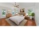 Bright bedroom featuring wood floors, neutral decor, and multiple windows for ample light at 1329 Gaston Loop, The Villages, FL 32162