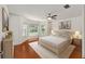 Comfortable bedroom boasting warm wood floors, natural light, and stylish, neutral furnishings at 1329 Gaston Loop, The Villages, FL 32162