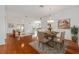 A dining room with wood floors, a chandelier, a table, and a view to the living room at 1329 Gaston Loop, The Villages, FL 32162