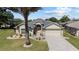 Charming single-story home boasts a paved driveway, two-car garage, and manicured landscaping under a clear sky at 1329 Gaston Loop, The Villages, FL 32162