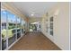 Bright sunroom featuring floor-to-ceiling windows with views of the landscaped backyard and an overhead ceiling fan at 1329 Gaston Loop, The Villages, FL 32162