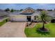 Charming single-story home with lush landscaping, well-manicured lawn, and a three car garage at 1454 Neuport Path, The Villages, FL 32163