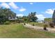 A beautifully landscaped backyard has a gazebo, a path, and a lush lawn at 16200 E Shirley Shores Rd, Tavares, FL 32778