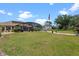Beautiful backyard featuring a spacious lawn, mature trees, and a screened-in pool area, ideal for relaxation at 16200 E Shirley Shores Rd, Tavares, FL 32778