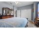 Neutral bedroom features a dresser with mirror, double closets, and view of ensuite doorway at 16200 E Shirley Shores Rd, Tavares, FL 32778