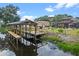 Picturesque view of a private dock with a covered sitting area overlooking the serene lake at 16200 E Shirley Shores Rd, Tavares, FL 32778