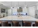 Bright kitchen with a large island featuring bar seating, stainless steel appliances, and modern lighting at 16200 E Shirley Shores Rd, Tavares, FL 32778