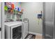 Functional laundry room with modern washer and dryer and shelving for storage at 16200 E Shirley Shores Rd, Tavares, FL 32778