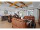 Open-concept living room with modern furnishings, wood beams, and seamless kitchen access at 16200 E Shirley Shores Rd, Tavares, FL 32778