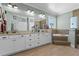 Luxurious bathroom showcasing a large vanity with dual sinks, soaking tub, and glass enclosed shower at 16200 E Shirley Shores Rd, Tavares, FL 32778