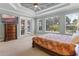 Spacious main bedroom boasts tray ceiling, large windows, and access to outdoor pool area at 16200 E Shirley Shores Rd, Tavares, FL 32778