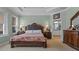 Elegant main bedroom features a decorative bed frame, side tables and neutral colors at 16200 E Shirley Shores Rd, Tavares, FL 32778