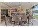 Outdoor kitchen with bar seating, a grill, sink, and TV for entertaining at 16200 E Shirley Shores Rd, Tavares, FL 32778