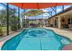 Gorgeous swimming pool in a screened enclosure and surrounded by lush landscaping and ample patio space at 16200 E Shirley Shores Rd, Tavares, FL 32778