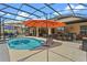 Inviting pool area with a screened enclosure, covered patio, and outdoor kitchen at 16200 E Shirley Shores Rd, Tavares, FL 32778
