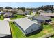 A view of the home's roof, manicured lawn and screened-in patio within a friendly neighborhood at 1633 Manserra St, The Villages, FL 32163