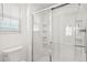 Bright bathroom featuring a glass enclosed shower, white tile, and a window with privacy blinds at 1633 Manserra St, The Villages, FL 32163