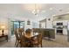Eat-in kitchen dining area with wood table, bar seating, and sliding door access to screened lanai at 1633 Manserra St, The Villages, FL 32163