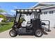 A Yamaha golf cart featuring full weather enclosure parked in front of a home at 1633 Manserra St, The Villages, FL 32163