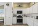 Kitchen with stainless steel appliances, white cabinetry, and a bright, airy feel at 1633 Manserra St, The Villages, FL 32163
