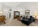 Cozy living room featuring a dark sectional, wood entertainment center, and neutral flooring at 1633 Manserra St, The Villages, FL 32163