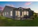 The screened-in patio with table and chairs invites relaxation and enjoyment of the outdoors at twilight at 1633 Manserra St, The Villages, FL 32163
