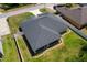 An aerial view showcasing the backyard and roof of this beautiful home, surrounded by a well-maintained lawn and white fence at 16380 Se 84Th Ct, Summerfield, FL 34491