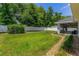 Well-maintained backyard with large lawn, covered patio area and white privacy fence at 16380 Se 84Th Ct, Summerfield, FL 34491