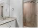 Tiled walk-in shower with glass door, complemented by a modern vanity with granite countertop at 16380 Se 84Th Ct, Summerfield, FL 34491
