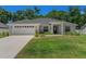 Charming single-story home features a manicured lawn, two car garage, and inviting front porch columns at 16380 Se 84Th Ct, Summerfield, FL 34491
