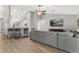 Open concept living room with bar seating, vaulted ceilings, and a comfortable gray sofa at 16380 Se 84Th Ct, Summerfield, FL 34491