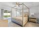Luxurious bedroom featuring a canopy bed and sliding glass doors at 16380 Se 84Th Ct, Summerfield, FL 34491