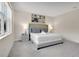 Comfortable bedroom with a tufted headboard, soft carpeting, and a window offering natural light at 17519 Hidden Forest Dr, Clermont, FL 34714