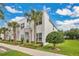 Contemporary townhomes featuring modern design, lush lawns, and palm tree landscaping at 17519 Hidden Forest Dr, Clermont, FL 34714