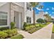 A modern townhome with stacked stone accents, lush landscaping, and a well-manicured lawn at 17519 Hidden Forest Dr, Clermont, FL 34714
