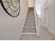 Bright staircase with carpeted steps and wood-look tile landing, illuminated by natural light at 17519 Hidden Forest Dr, Clermont, FL 34714