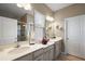 Bathroom featuring double sinks, granite countertops, a framed mirror, and modern fixtures at 456 Winter Solstice Ln, Mount Dora, FL 32757