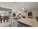 Granite kitchen island with sink and stainless steel dishwasher in an open floorplan at 456 Winter Solstice Ln, Mount Dora, FL 32757