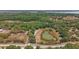 Aerial view of property showcases a serene pond surrounded by abundant trees at 5787 Marion County Rd, Lady Lake, FL 32159