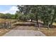Gated property entrance with gravel drive and mature trees at 5787 Marion County Rd, Lady Lake, FL 32159