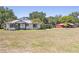 Quaint house with tidy yard, red barn, mature trees, and inviting facade at 602 Cr 489, Lake Panasoffkee, FL 33538