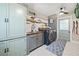 Well-organized laundry room with gray cabinets, patterned floor, modern washer/dryer, and stylish decor at 602 Cr 489, Lake Panasoffkee, FL 33538