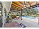 An inviting covered patio overlooks a sparkling swimming pool with lush greenery and shady trees at 602 Cr 489, Lake Panasoffkee, FL 33538