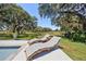 Relax poolside on comfortable lounge chairs, shaded by mature trees and surrounded by a lush green landscape at 602 Cr 489, Lake Panasoffkee, FL 33538