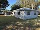 An angled view of a single-story home featuring a screened porch and metal roof with a partially obscured chain link fence in front at 608 Gray Ave, Wildwood, FL 34785