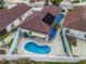 An aerial view of a home with a private pool, awnings, and solar panels on the roof in a residential neighborhood at 632 Delgado Ave, The Villages, FL 32159